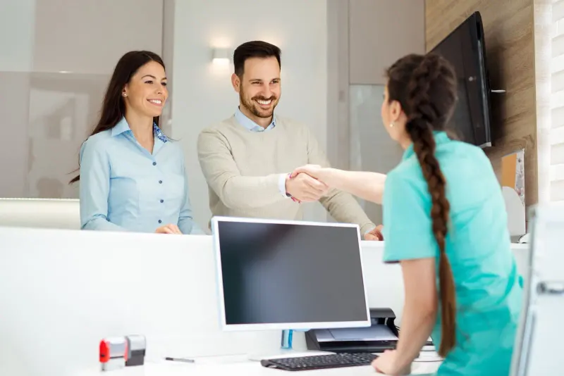 Front desk team member greeting a smiling patient