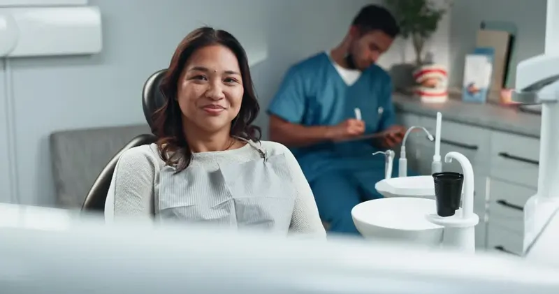 Smiling patient in the chair with a surgical assistant